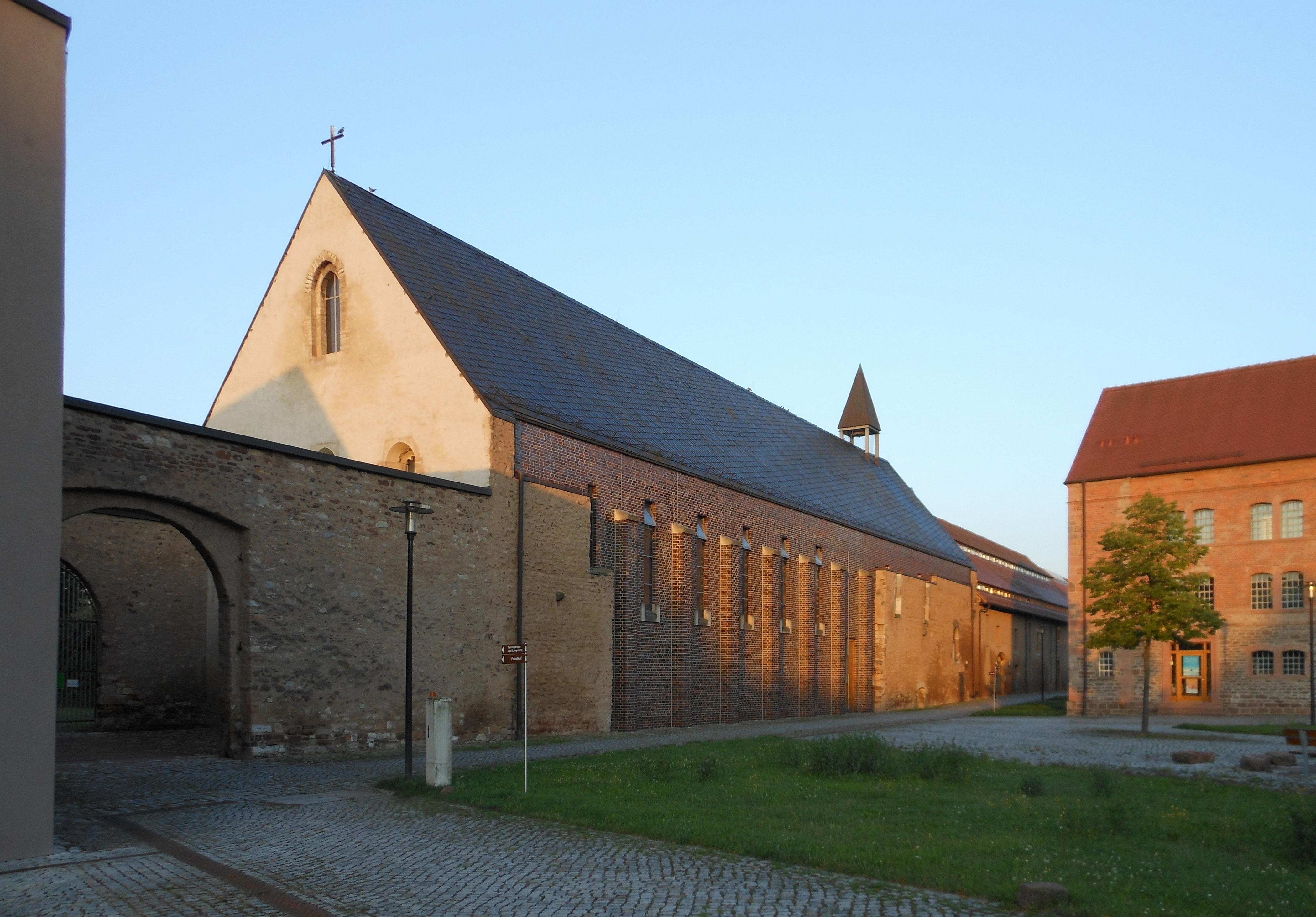 The Church at Helfta with a lawn in front and at gate next to the church on the left side of the image